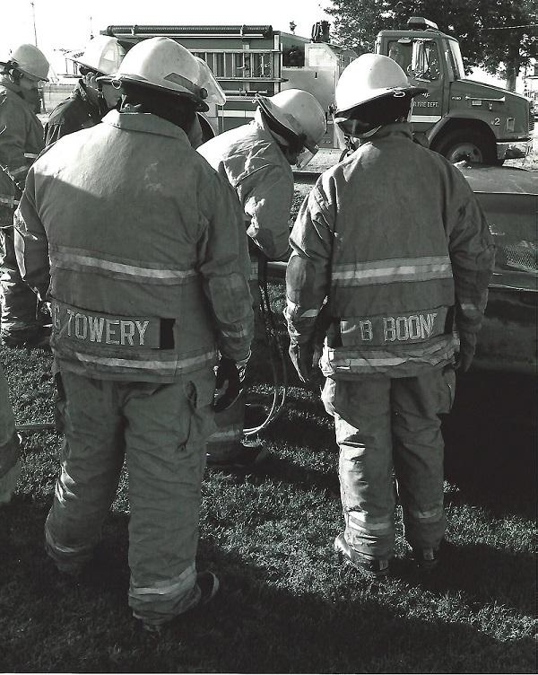3 firemen in uniform with backs to camera